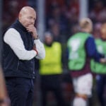 Danmarks missede VM-billet har udløst total krig mellem DBU og eksperterne, hvor landstræner Brian Riemer er under vild beskydning.